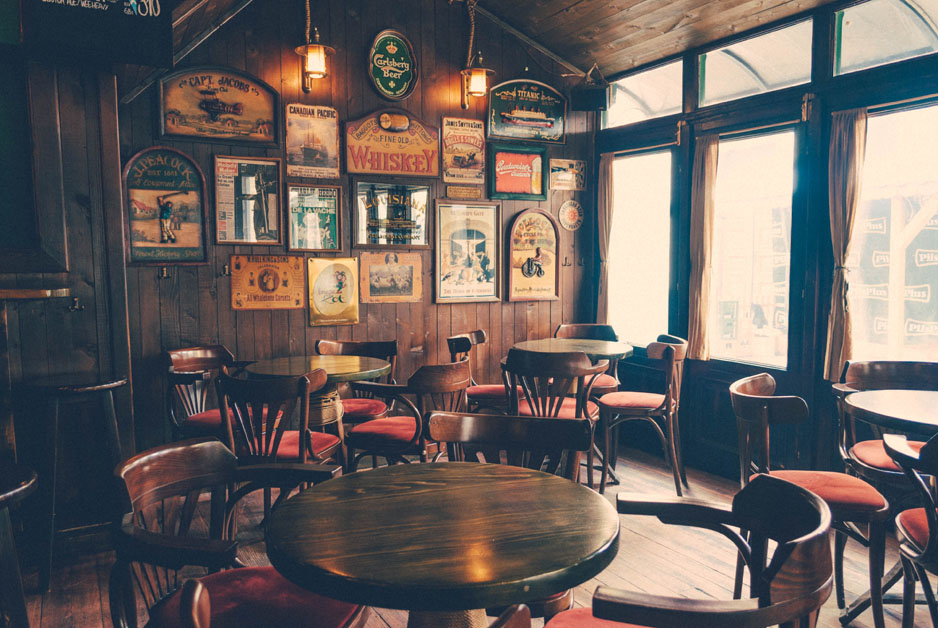 rustic looking tap house with vintage signs on the wall and wooden tables