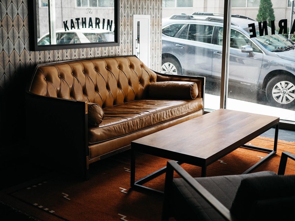 long leather office chair with window to the right and a car parked on the road